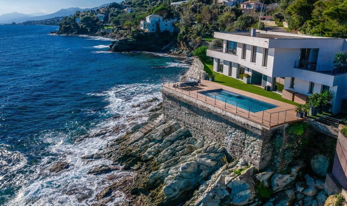 Villa contemporaine en Corse avec terrasse en bois composite Nuances Ipé de Silvadec et piscine à débordement sur structure aluminium Réversil, offrant une vue panoramique sur la Méditerranée